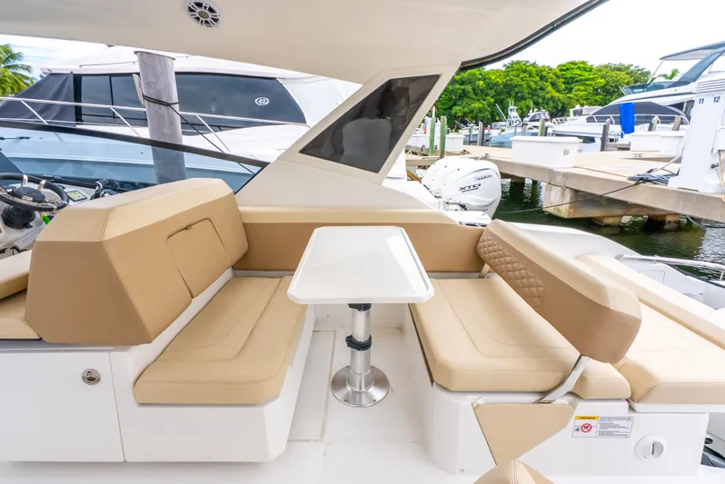 Ohana Yacht Photos Pics Luxurious seating area on a 2020 Aquila 32 yacht, featuring beige cushions and a sleek white table.