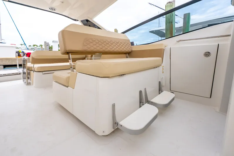 Ohana Yacht Photos Pics Interior seating of a 2020 Aquila 32 boat with beige cushions and footrests.