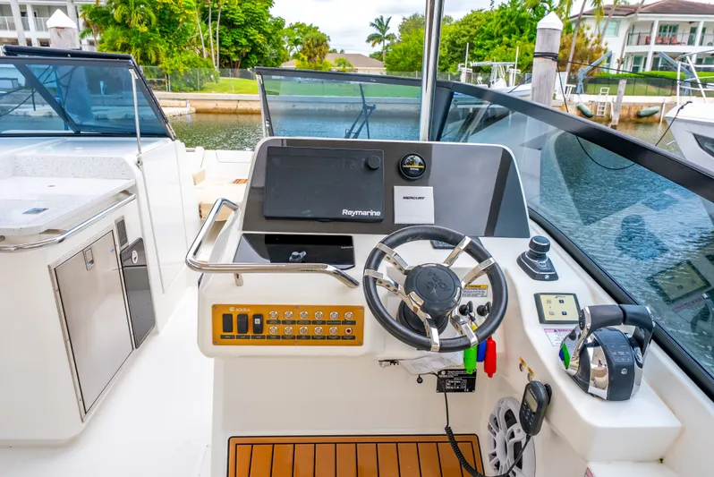 Ohana Yacht Photos Pics Cockpit of 2020 Aquila 32 boat with steering wheel and control panel.