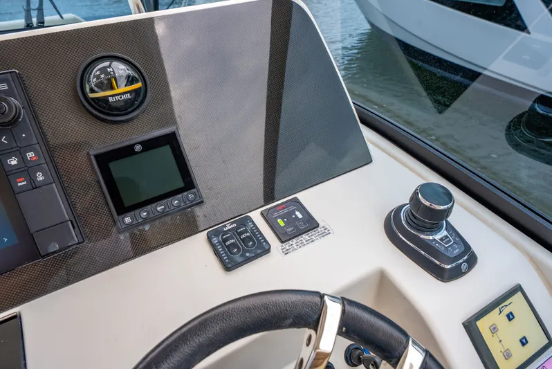 Ohana Yacht Photos Pics Control panel of a 2020 Aquila 32 boat with navigation instruments and joystick.