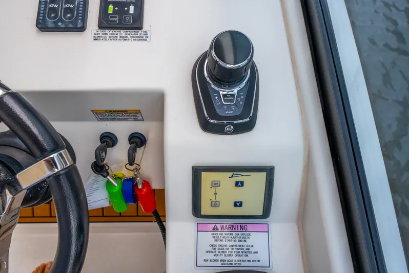 Ohana Yacht Photos Pics Control panel of a 2020 Aquila 32 boat with steering wheel and warning labels.