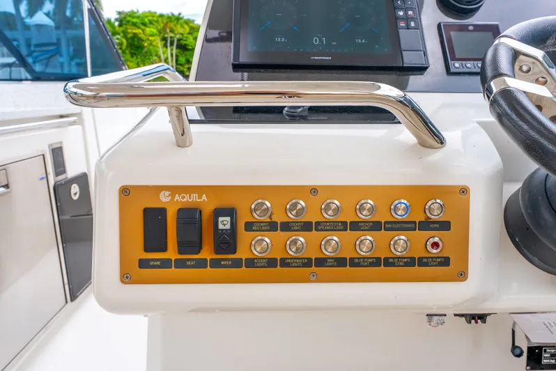Ohana Yacht Photos Pics Control panel of a 2020 Aquila 32 boat with various switches and buttons.