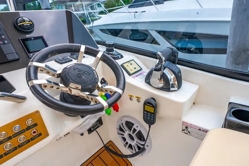 Ohana Yacht Photos Pics Steering console of a 2020 Aquila 32 boat with controls and navigation equipment.