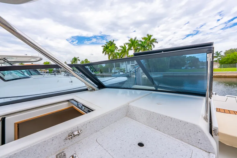 Ohana Yacht Photos Pics 2020 Aquila 32 yacht with sleek design, docked near palm trees and waterway.