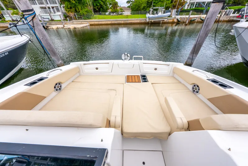 Ohana Yacht Photos Pics Aquila 32 boat interior with beige seating, docked by a calm waterfront.
