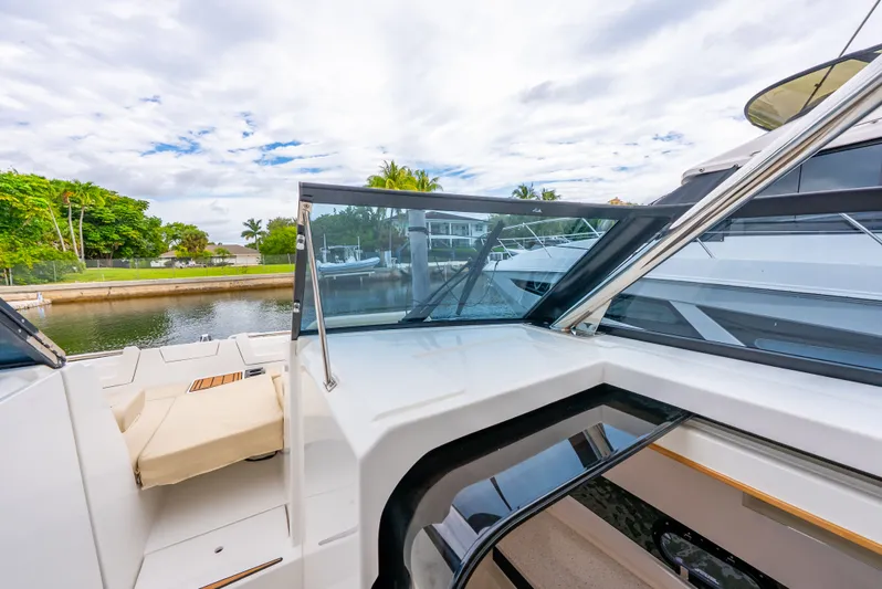 Ohana Yacht Photos Pics Aquila 32 yacht, 2020 model, docked by a serene waterfront with lush greenery.