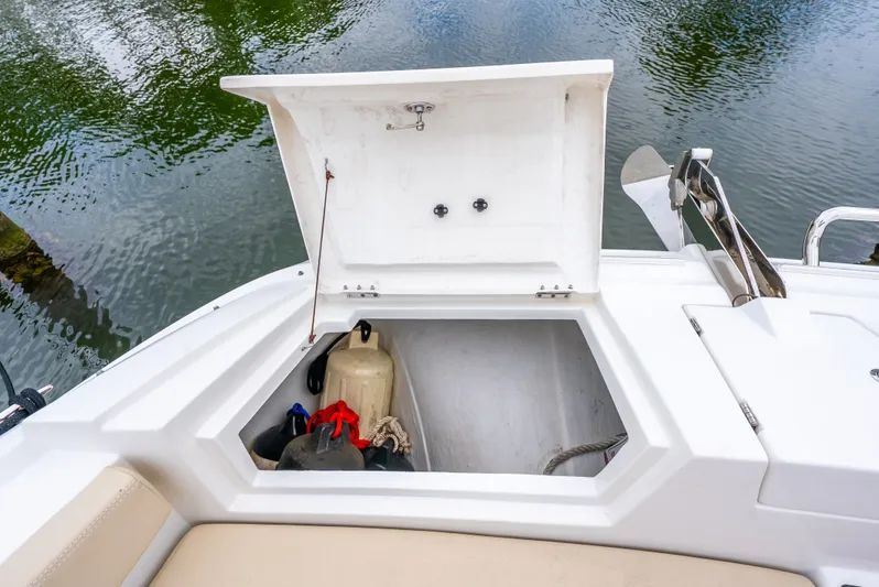 Ohana Yacht Photos Pics Open storage compartment on 2020 Aquila 32 boat, showing equipment and water reflection.