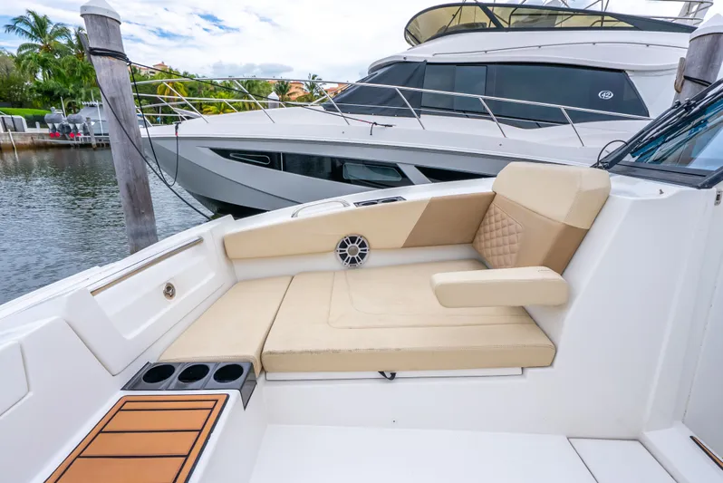 Ohana Yacht Photos Pics Luxury seating on a 2020 Aquila 32 yacht, docked near another vessel.