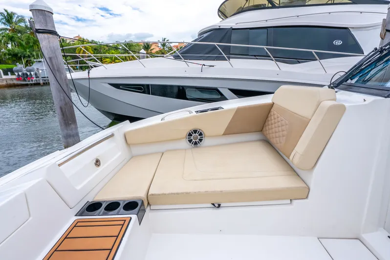 Ohana Yacht Photos Pics Aquila 32 boat interior with beige seating, cup holders, and sleek design, docked by the water.
