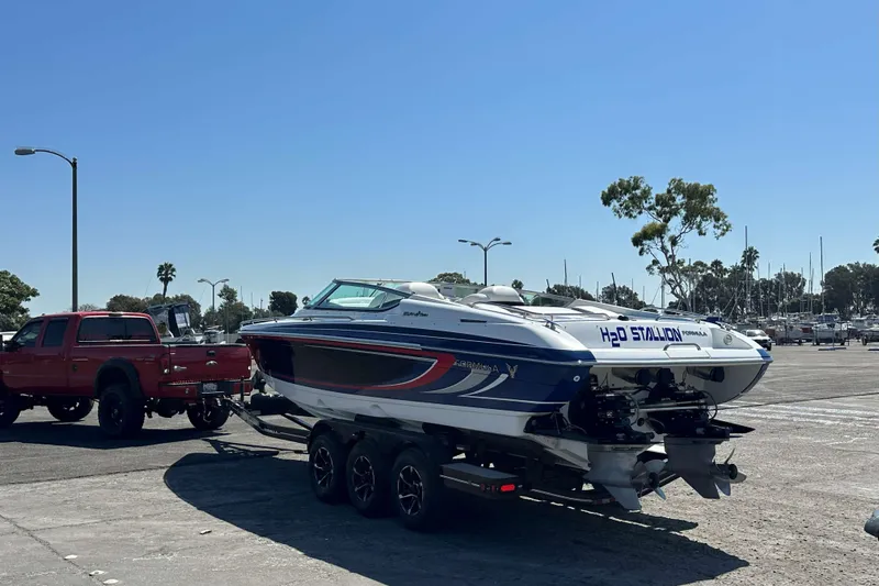  Yacht Photos Pics 2004 Formula 292 FASTech boat on trailer, towed by red truck at marina parking lot.