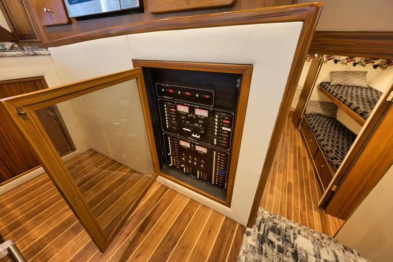 Grand Slam Yacht Photos Pics Electrical panel inside 2004 Guthrie 60 Custom Carolina yacht, featuring wooden flooring and cozy cabin.