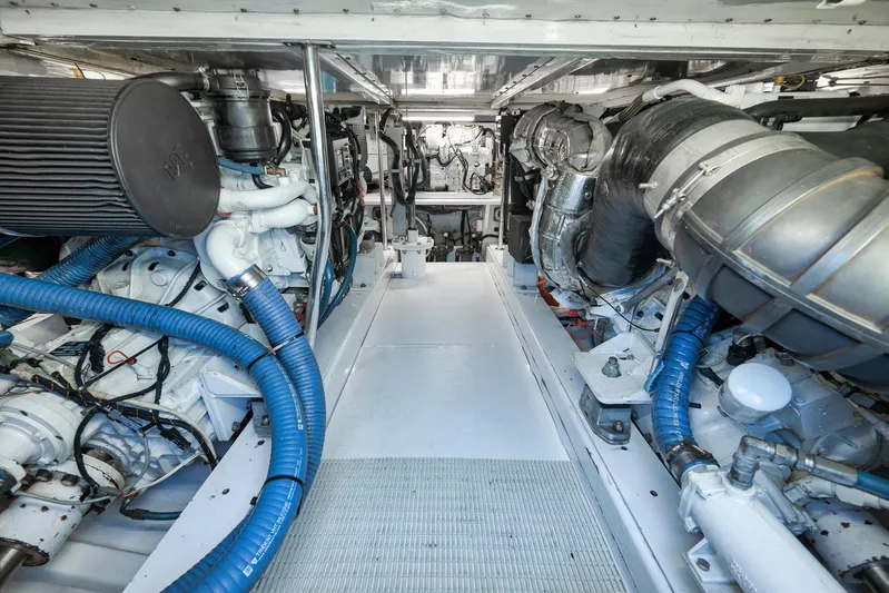 Grand Slam Yacht Photos Pics Engine room of 2004 Guthrie 60 Custom Carolina boat, featuring complex machinery and blue hoses.