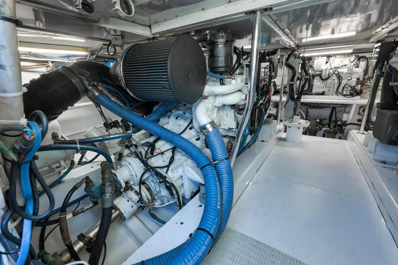 Grand Slam Yacht Photos Pics Engine room of 2004 Guthrie 60 Custom Carolina boat, featuring complex machinery and blue hoses.