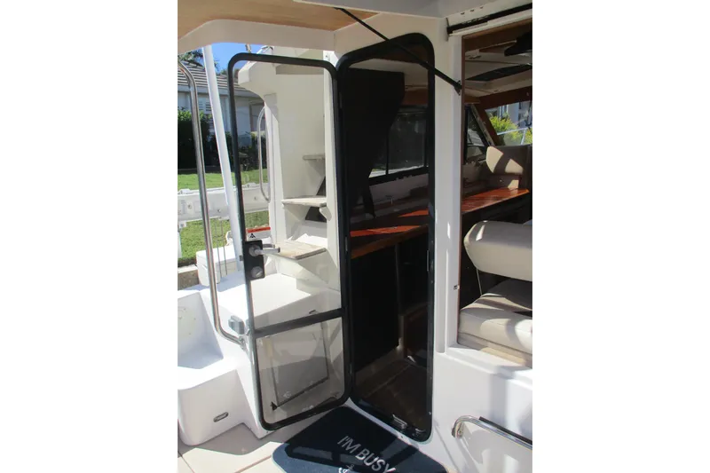 I'm Busy Yacht Photos Pics 2015 Cutwater 30 Command Bridge LE boat interior with open door and seating area.