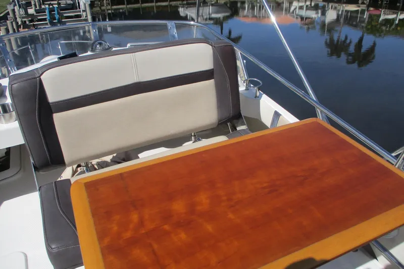 I'm Busy Yacht Photos Pics 2015 Cutwater 30 Command Bridge LE boat interior with wooden table and cushioned seating.