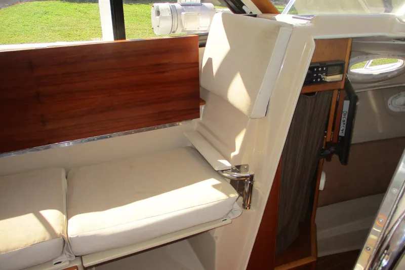 I'm Busy Yacht Photos Pics Interior of 2015 Cutwater 30 Command Bridge LE, featuring cushioned seating and wooden accents.