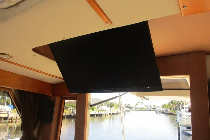 I'm Busy Yacht Photos Pics Interior of 2015 Cutwater 30 Command Bridge LE with ceiling-mounted TV and marina view.