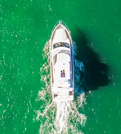 Sipsip Yacht Photos Pics Aerial view of 2018 Absolute 52 FLY yacht cruising in vibrant green waters.