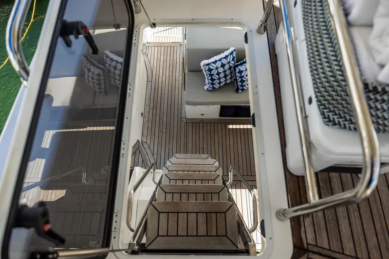 Sipsip Yacht Photos Pics Staircase view on 2018 Absolute 52 FLY yacht with wooden deck and patterned cushions.