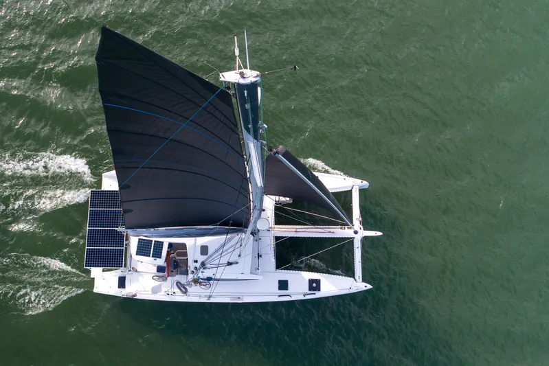 Rima Yacht Photos Pics Aerial view of 2018 Outremer 51 catamaran sailing with black sails and solar panels.