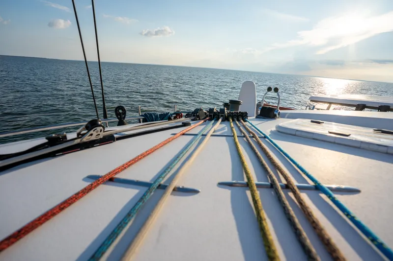 Rima Yacht Photos Pics 2018 Outremer 51 sailboat deck with colorful ropes, ocean view, and sunset.
