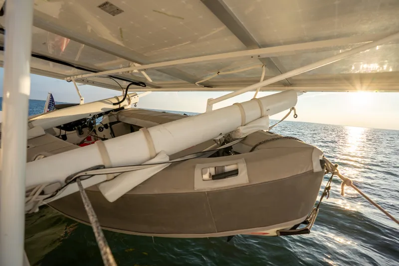 Rima Yacht Photos Pics 2018 Outremer 51 catamaran with dinghy, ocean view at sunset.