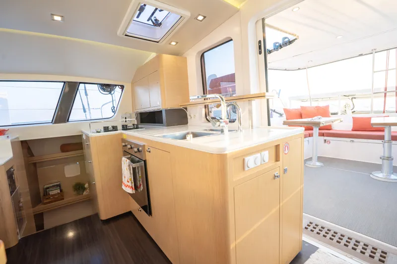 Rima Yacht Photos Pics Modern interior of 2018 Outremer 51 catamaran featuring kitchen and seating area.