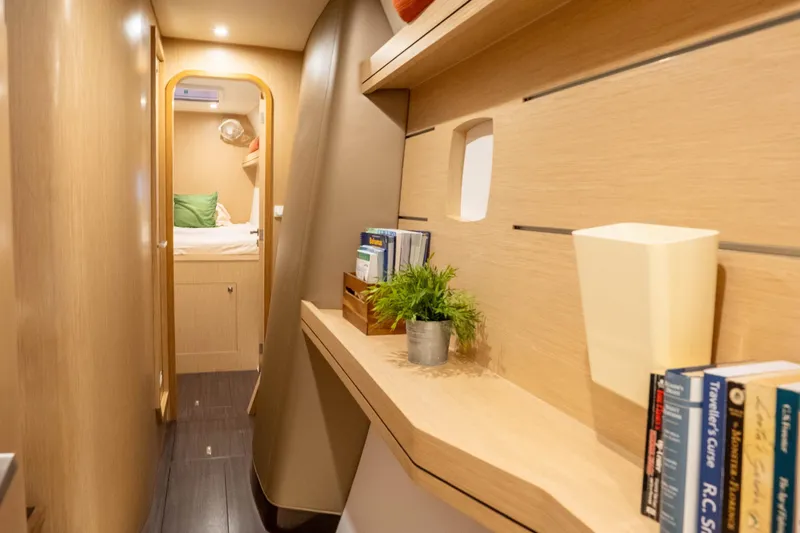 Rima Yacht Photos Pics Interior of 2018 Outremer 51 yacht, featuring a cozy cabin with books and decor.