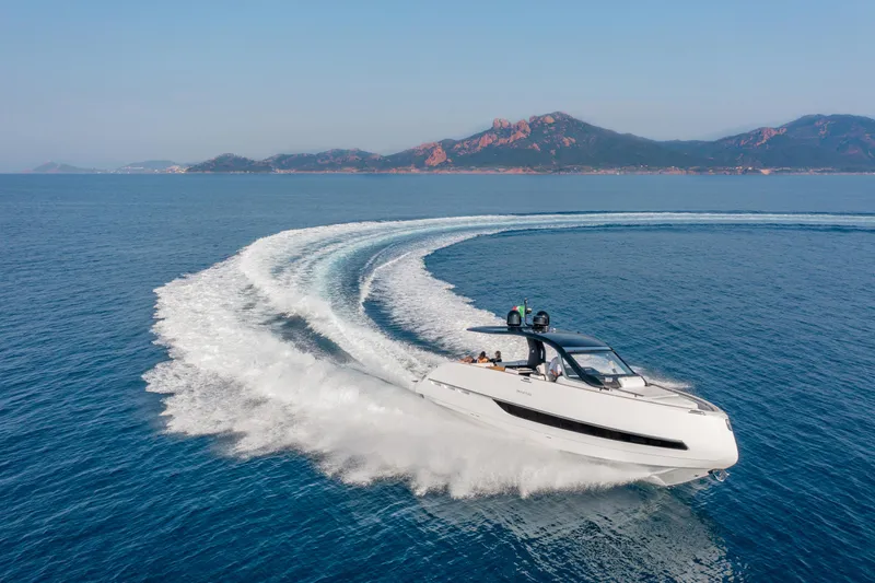  Yacht Photos Pics Invictus TT420 yacht cruising on open sea, 2025 model, with scenic mountain backdrop.