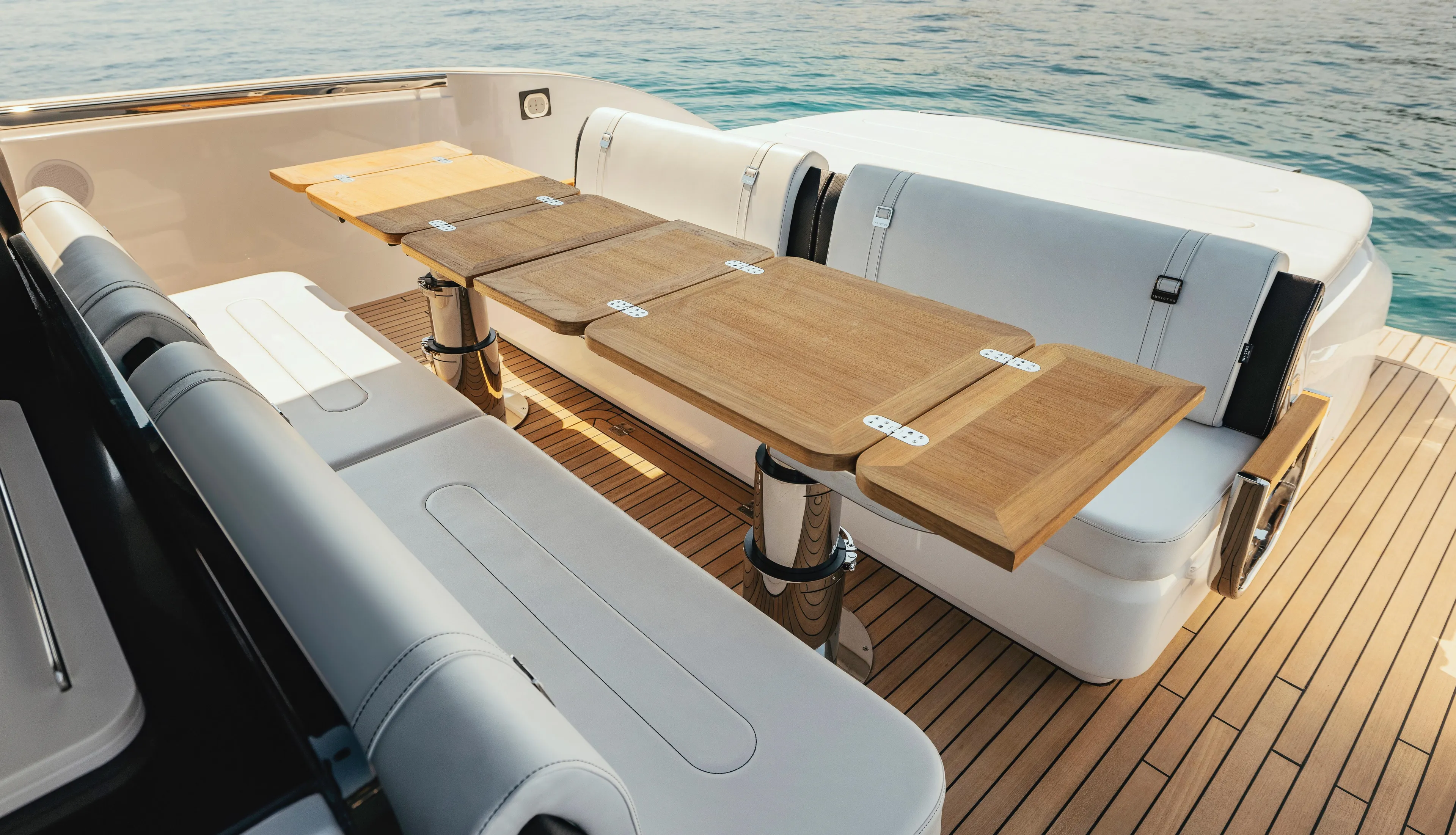  Yacht Photos Pics Luxury seating area on 2025 Invictus TT420 yacht with wooden table and ocean view.