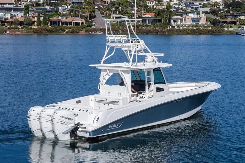 Vaquero Chingon Yacht Photos Pics 2016 Boston Whaler 370 Outrage boat on calm water near coastal homes.