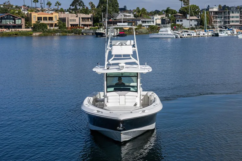 Vaquero Chingon Yacht Photos Pics 2016 Boston Whaler 370 Outrage cruising on calm waters near waterfront homes.