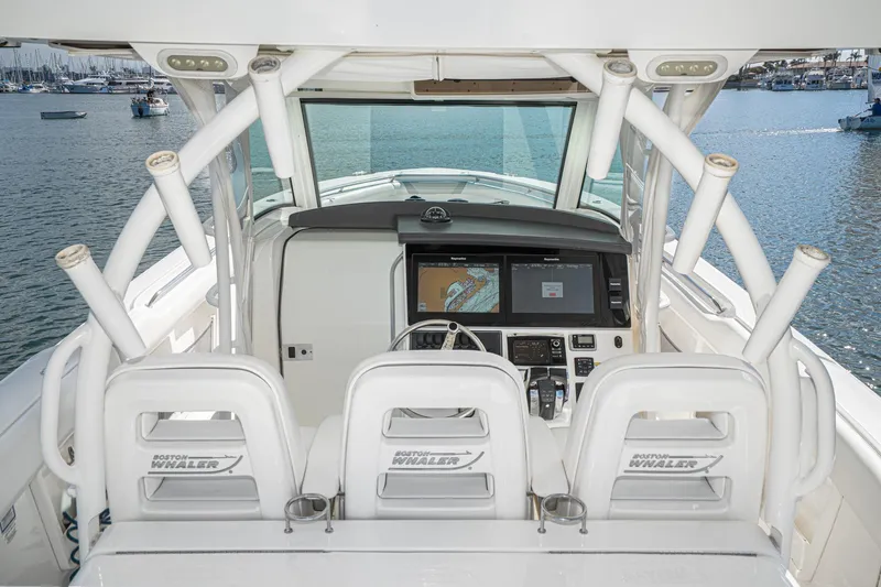 Vaquero Chingon Yacht Photos Pics 2016 Boston Whaler 370 Outrage helm with navigation screens, docked in a marina.