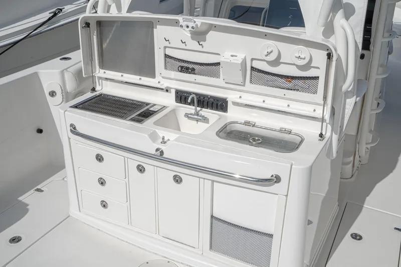 Vaquero Chingon Yacht Photos Pics 2016 Boston Whaler 370 Outrage boat galley with sink, grill, and storage compartments.