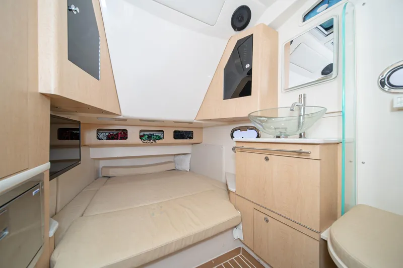 Vaquero Chingon Yacht Photos Pics 2016 Boston Whaler 370 Outrage cabin interior with bed, sink, and storage.