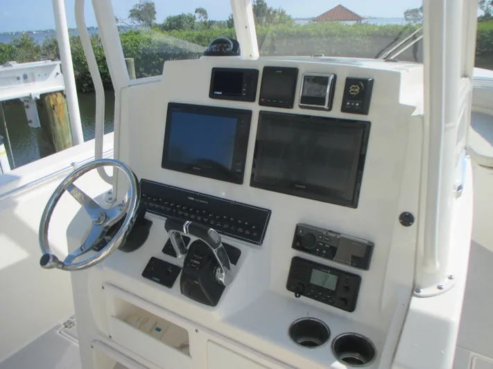  Yacht Photos Pics 2018 Cobia 301 Center Console boat dashboard with steering wheel and electronic controls.
