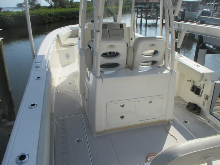  Yacht Photos Pics 2018 Cobia 301 Center Console boat interior with seating and storage, docked by the water.