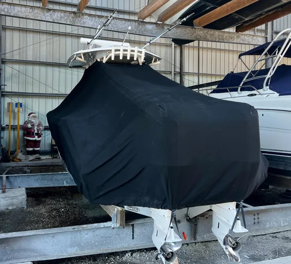  Yacht Photos Pics 2018 Cobia 301 Center Console boat covered in black tarp, stored indoors.