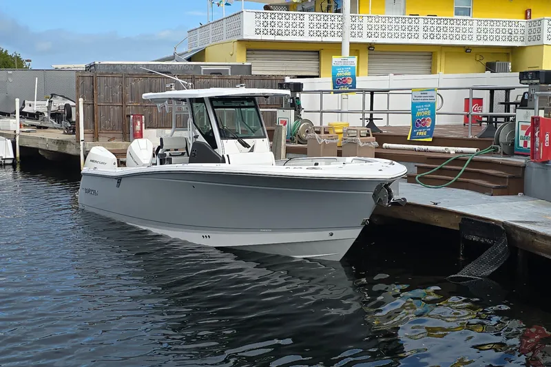  Yacht Photos Pics 2023 Blackfin 302 CC boat docked at marina with yellow building background.