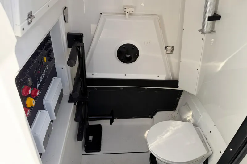  Yacht Photos Pics 2023 Blackfin 302 CC boat interior with control panel and compact toilet.