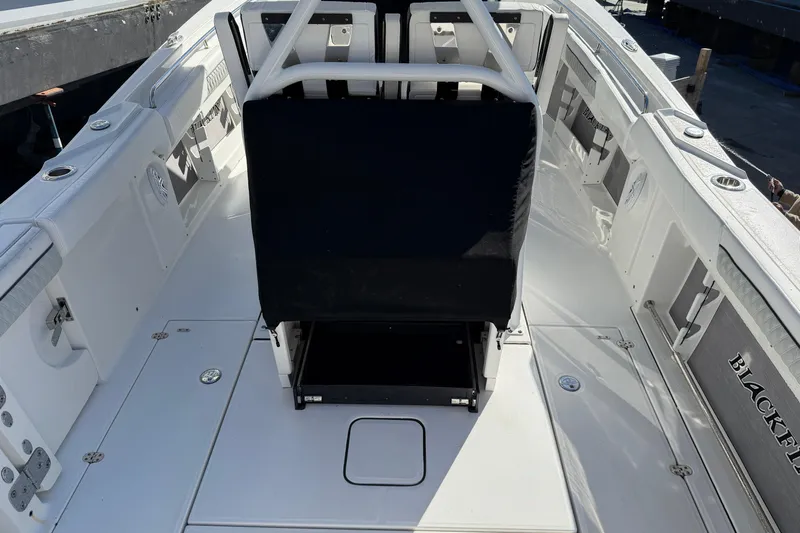 Yacht Photos Pics 2023 Blackfin 302 CC boat interior, featuring sleek white deck and seating area.