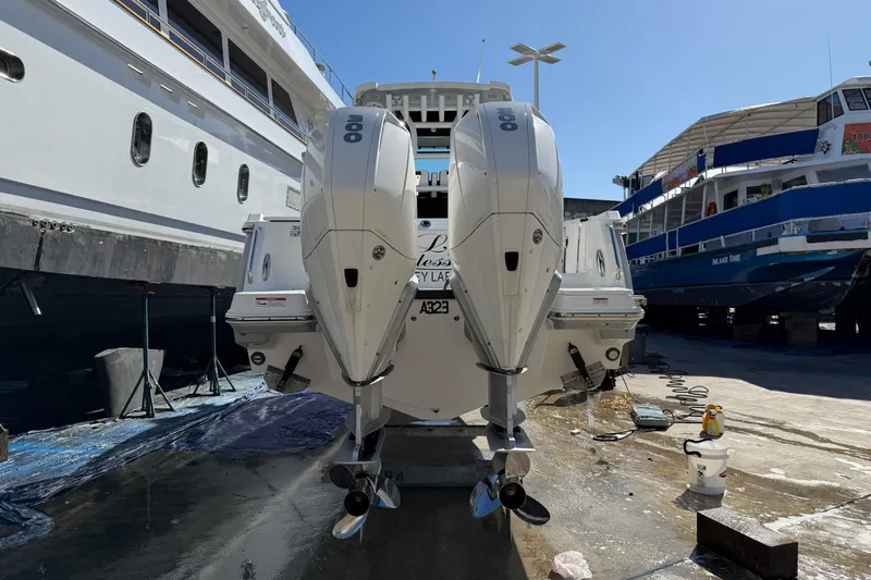  Yacht Photos Pics 2023 Blackfin 302 CC boat with dual outboard engines in a shipyard setting.