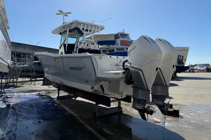  Yacht Photos Pics 2023 Blackfin 302 CC boat with dual outboard engines on a dock.
