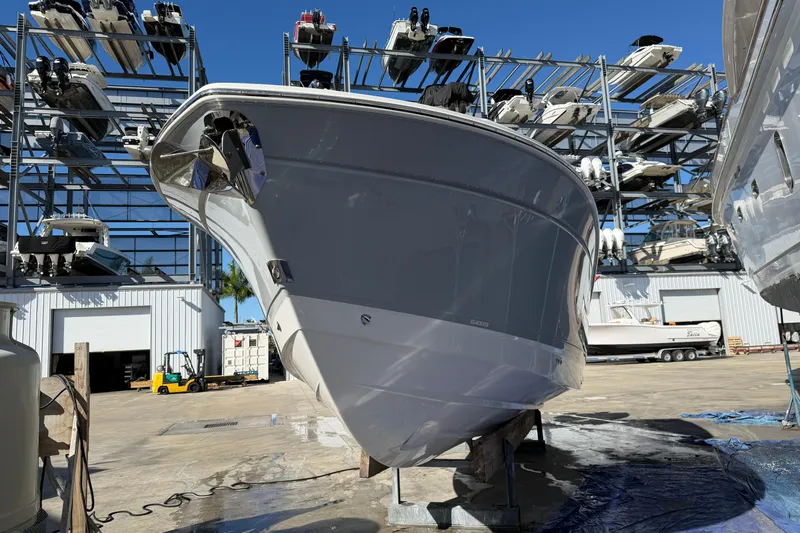  Yacht Photos Pics 2023 Blackfin 302 CC boat in storage yard with stacked boats in background.