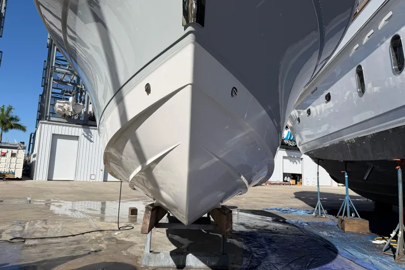  Yacht Photos Pics 2023 Blackfin 302 CC boat on dry dock, showcasing sleek hull design.