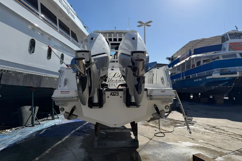  Yacht Photos Pics 2023 Blackfin 302 CC boat with dual outboard motors in a shipyard setting.