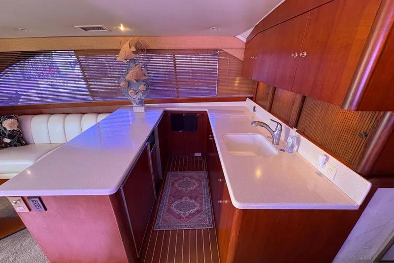 Fender Bender Yacht Photos Pics Luxurious kitchen interior of 1996 Ocean Yachts 48 Super Sport with wooden cabinetry and modern amenities.