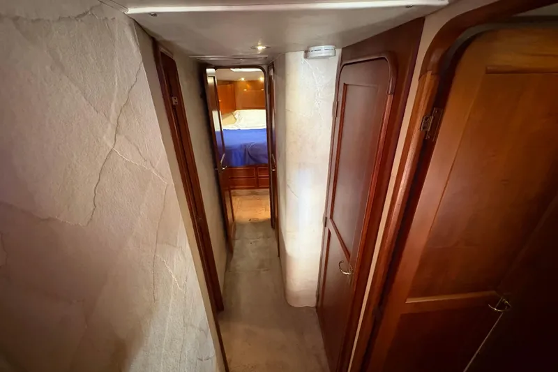 Fender Bender Yacht Photos Pics Narrow hallway inside 1996 Ocean Yachts 48 Super Sport, featuring wooden doors and cozy lighting.