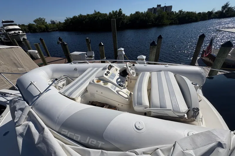 Fender Bender Yacht Photos Pics Inflatable boat on 1996 Ocean Yachts 48 Super Sport, docked by a serene waterfront.