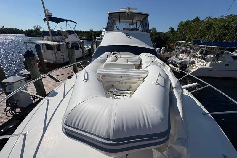 Fender Bender Yacht Photos Pics 1996 Ocean Yachts 48 Super Sport with inflatable boat on deck, docked at marina.